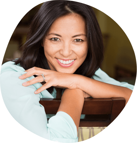 Smiling woman leaning over the back of a wooden chair