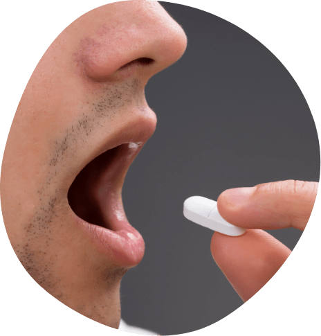 Close up of person placing a white pill in their mouth