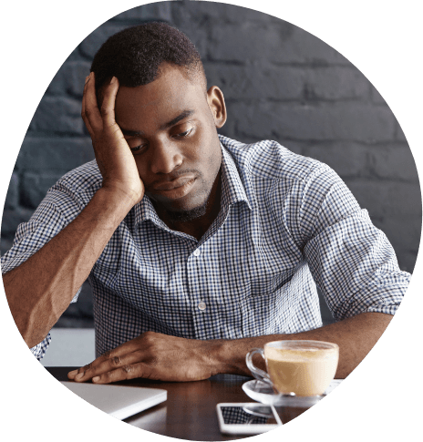 Tired man sitting at desk and resting his head in his hand