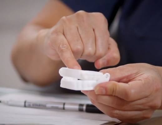 Person holding a white oral appliance