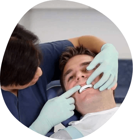 Sleep doctor fitting a male patient with an oral appliance
