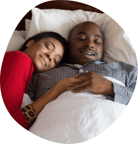 Smiling man and woman cuddling while sleeping