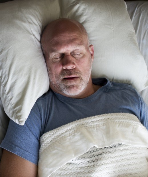 Older man sleeping soundly after sleep apnea treatment in Irving
