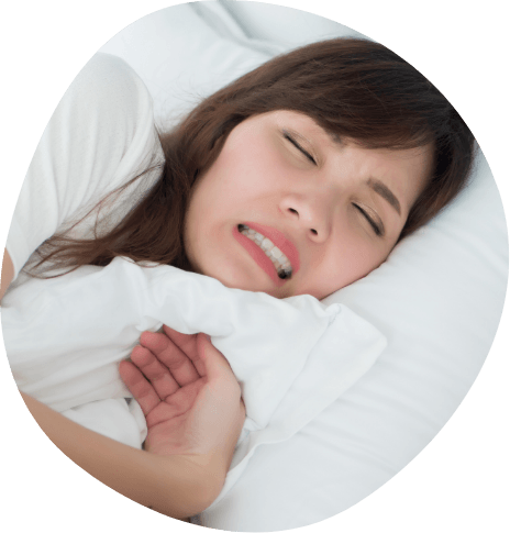 Woman grimacing while laying in bed