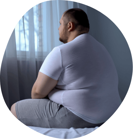 Chubby man sitting on edge of bed
